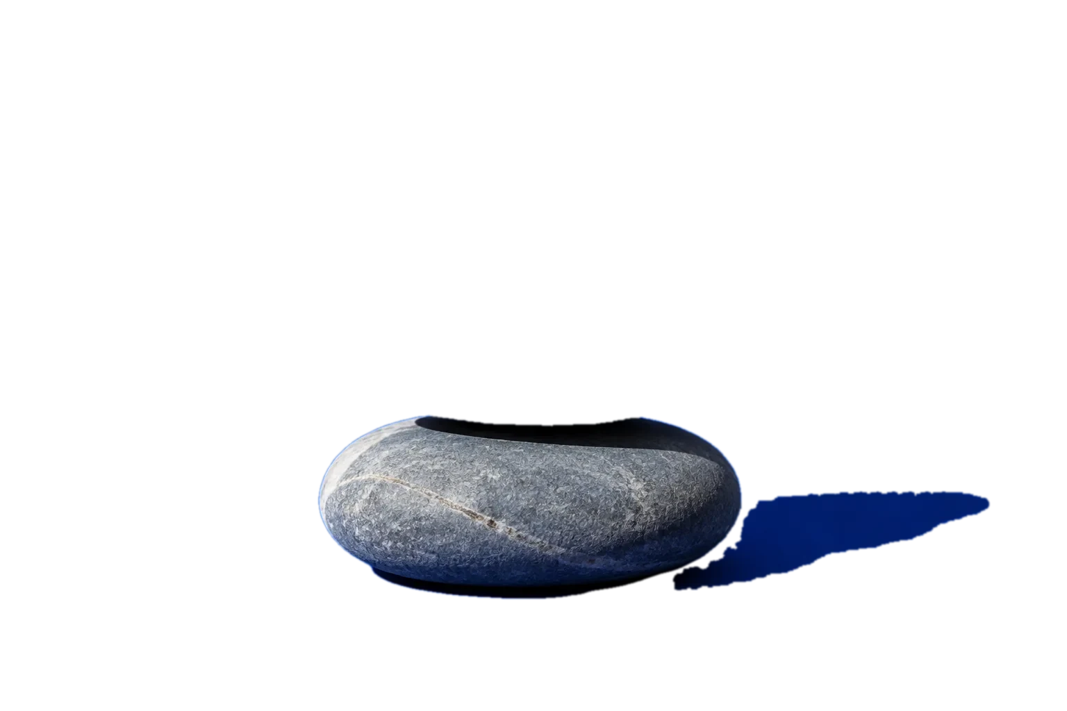 Three grey stones stacked on a cobalt studio backdrop